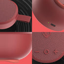 Altavoz inalámbrico portátil Skullcandy SlowBack rojo, pequeño y redondo, con rejilla negra y correa.