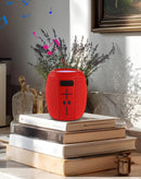 Altavoz inalámbrico BASE rojo con correa portátil, sonido potente y diseño moderno.